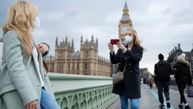 Tourists taking photos while exploring London landmarks.