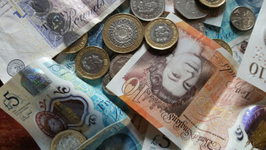 Silver and gold coins placed on a British banknote