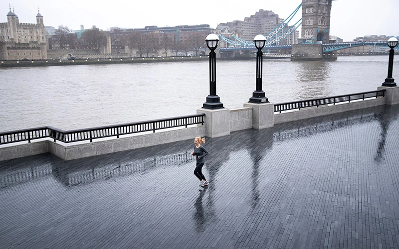 Woman running in the rain outdoors in the UK