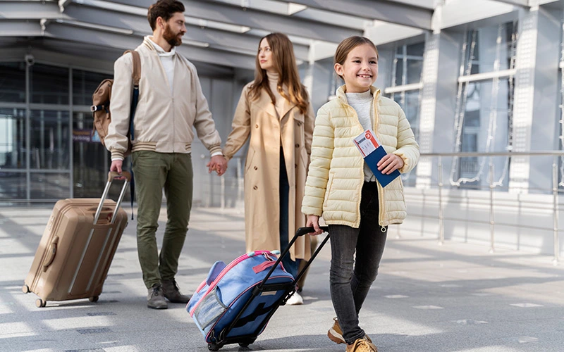 Full shot of parents and child walking with luggage while traveling