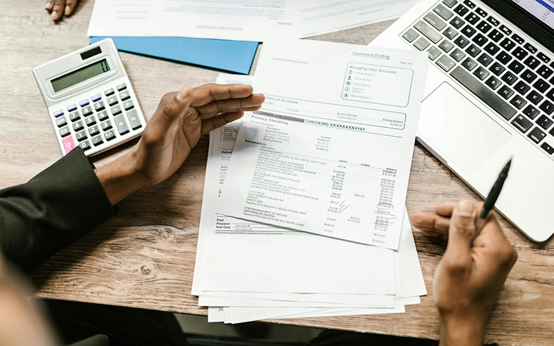 White papers and bank statements are placed on a table