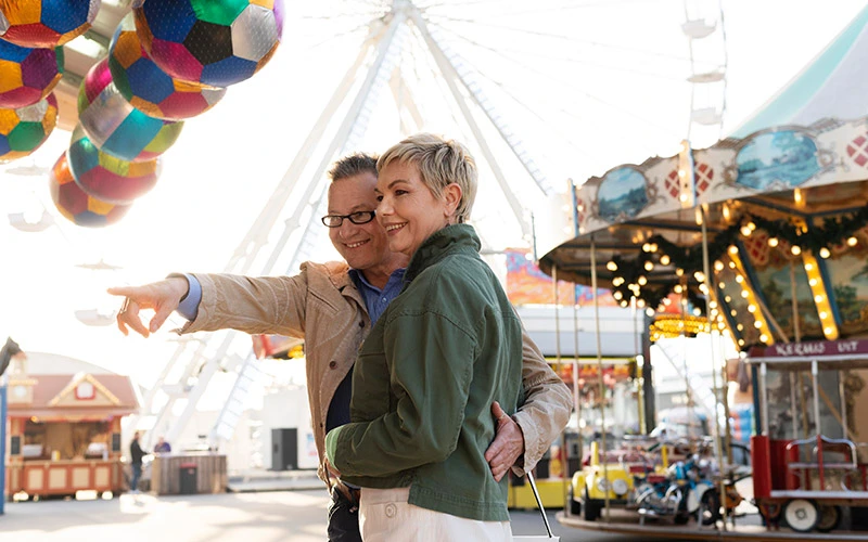 Middle-aged couple smiling and enjoying a festival in London.